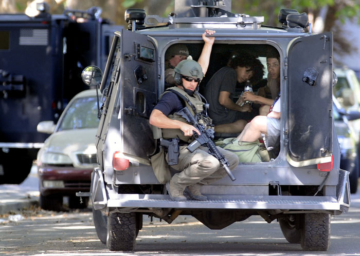 Members of the Tri-City Regional SWAT Team escort neighbors out the vicinity of an apartment where a man barricaded himself inside his apartment at West 21st Avenue and South Rainier Street in Kennewick after he pointed what a gun at a woman early on Friday morning. The man has been arrested and taken into custody.