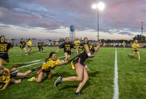 The seniors Tevyn Waddell drags junior Haylee Schoenfelder while carrying the ball during the annual powder puff football game at Joe Quintal Field on Thursday night in Mitchell as part of homecoming week. The seniors beat the juniors 28-0. (Matt Gade/Republic)