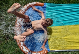Canon Moller (8) goes down the slip n slide while hanging out at the Widstrom's on Wednesday afternoon. Today's forecast calls for a slight chance of showers and thunderstorms after 1pm. Mostly cloudy, with a high near 80. Chance of precipitation is 20%. (Matt Gade/Republic)