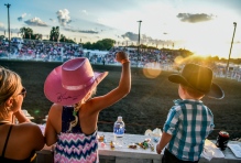 Eight-year-old Jaycee pumps her fist while watching the bareback riding competition with mom Caitlyn Lachnit, left, and brother Tayton (2), all of Alexandria, on Thursday night during the first night of the 45th annual Corn Palace Stampede Rodeo at Horseman Arena in Mitchell.(Matt Gade/Republic)