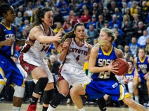 South Dakota State University's Chloe Cornemann (22) looks for an outlet after making a rebound in front of University of South Dakota's Kate Liveringhouse (34) and University of South Dakota's Tia Hemiller (4) during a game in the Summit League conference championship on Tuesday at the Denny Sanford Premier Center in Sioux Falls. (Matt Gade/Republic)