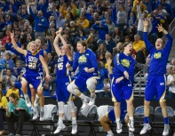 The Jackrabbits bench celebrate a 3-point basket by South Dakota State University's Madison Guebert (11) during a game in the Summit League conference championship on Tuesday at the Denny Sanford Premier Center in Sioux Falls. (Matt Gade/Republic)
