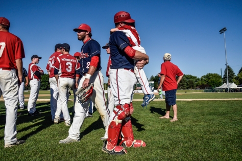 The Alexandria Angels' Chris Marek hugs his son, and the team's bat boy, Rhett Marek after defeating the Garretson Blue Jays 7-1 in the Class B state amateur championship game on Sunday at Cadwell Park in Mitchell.
