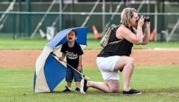 A young Alexandria fan cries after shouting "I want to be in the picture" and wasn't allowed to be a part of a group picture after the Angels win over the Larchwood Diamonds for the Class B state amateur baseball championship game on Sunday at Cadwell Park.